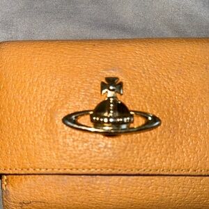 Vivienne Westwood Tan and Gold Leather Wallet(Kisslock) were on the edges.